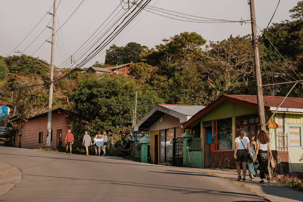 road with buildings and people watching and greenery leading to Monteverde Cloud Forest reserve