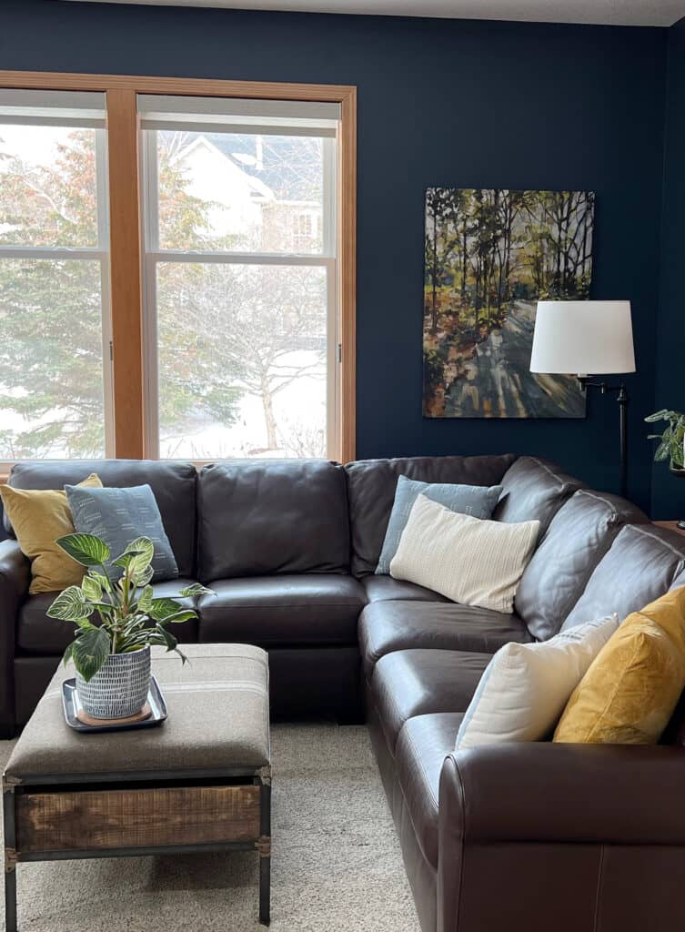 Benjamin MooreHale Navy with orange stain on wood trim, and leather sectional. Beige carpet, great accent wall color. Kylie M ONline paint color consulting