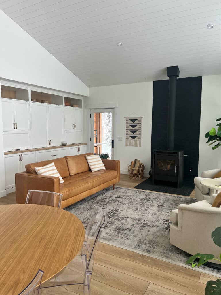 Tongue and groove ceiling, mountain style, ski chalet, Benjamin Moore Oxford White, cognac leather sofa, wood floor, wood stove