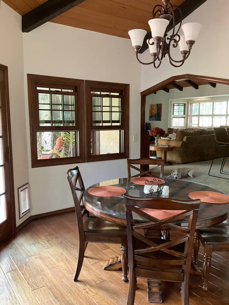 Dining room with wood ceiling and beams, dark wood trim, Benjamin Moore Spanish White off-white cream paint color on walls