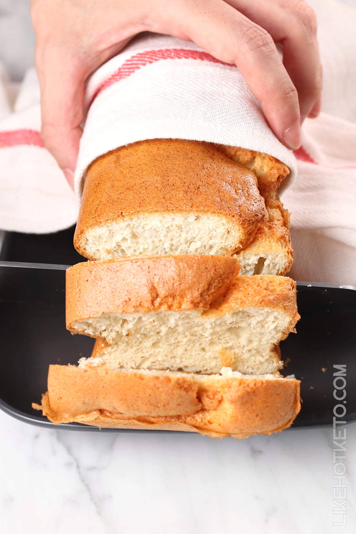 Keto protein sparing bread being sliced with a bread knife.