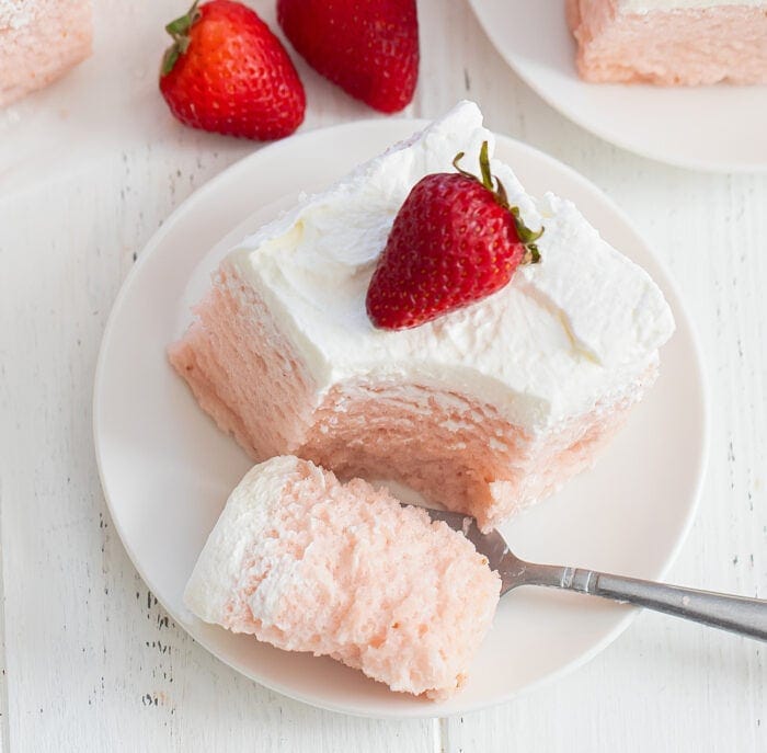 a slice on a plate with a fork with a bite of cake.